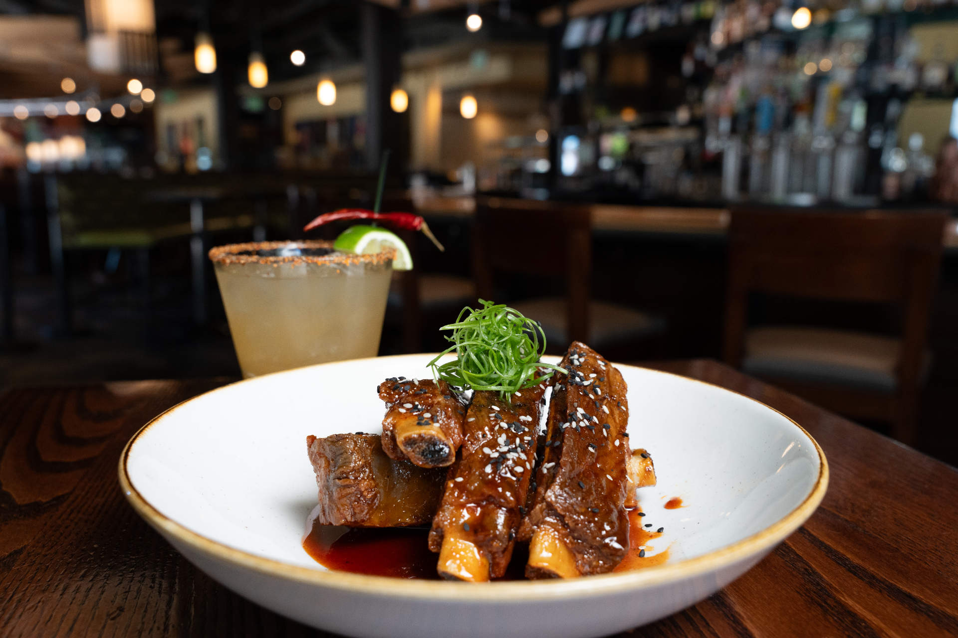 Braised short ribs with sesame seeds and scallions beside a spicy margarita